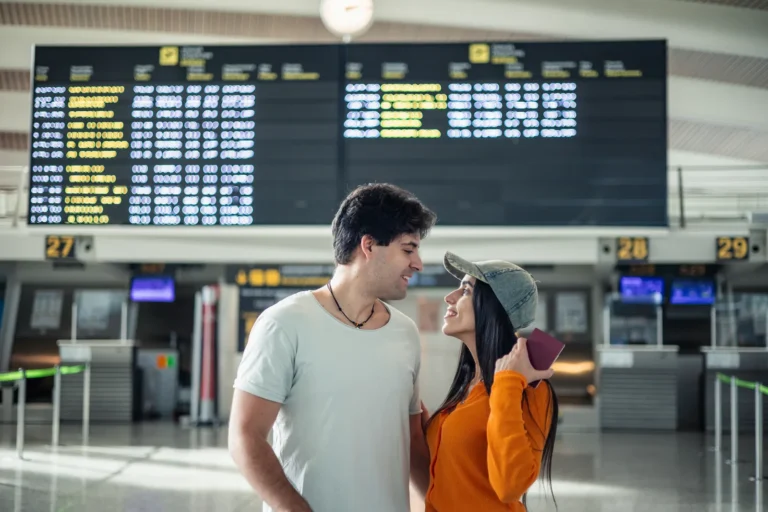 Young couple in an airport terminal in front of the departures board