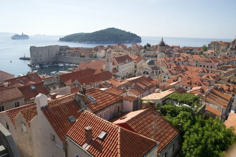 Red rooftops of Dubrovnik Old Town with the old harbour and Lokrum island in the Adriatic Sea