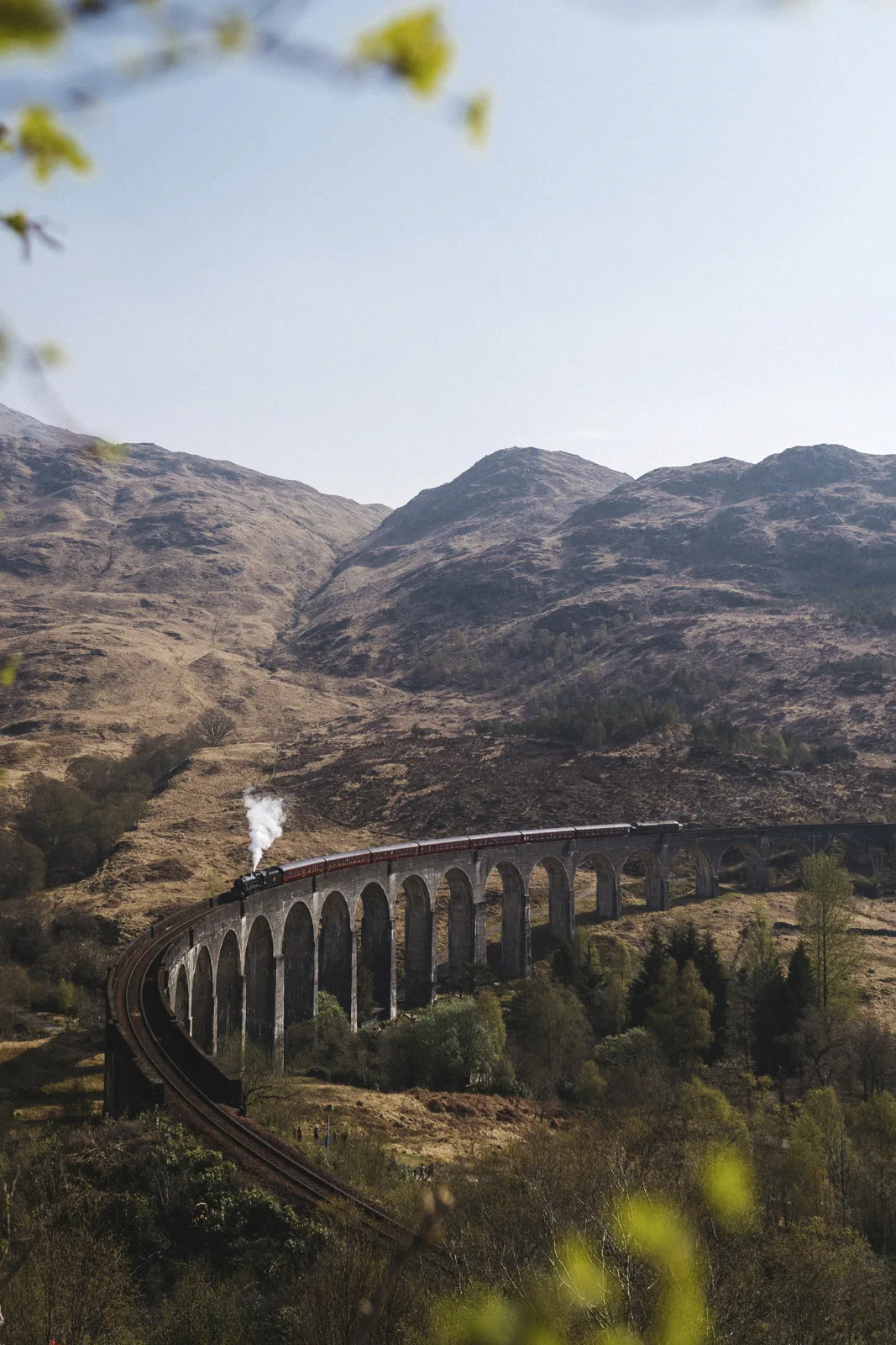 Steam train crossing the Glenfinnan Viaduct in the Scottish Highlands
