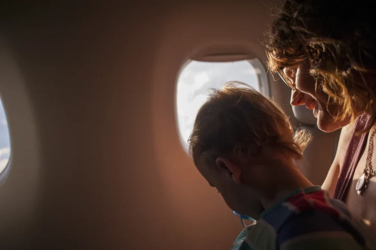 Mother and young son looking out of an airplane window