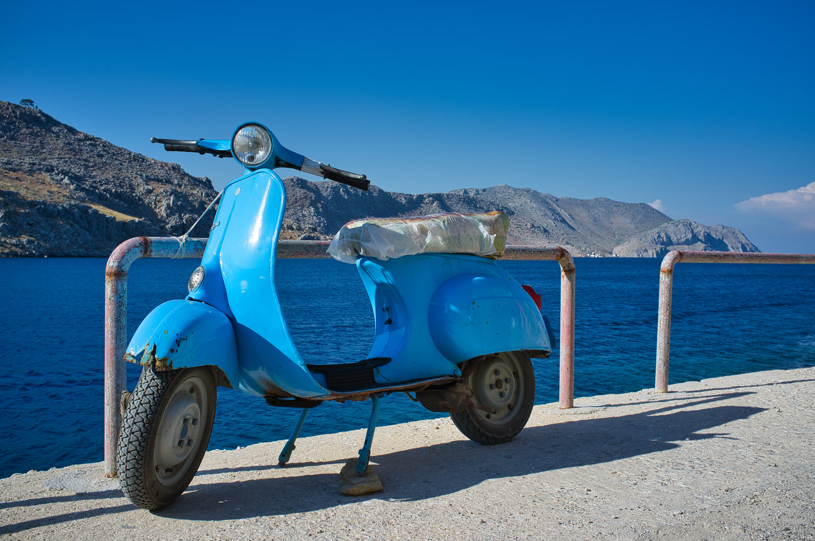 Scooter parked by the sea on a Greek island