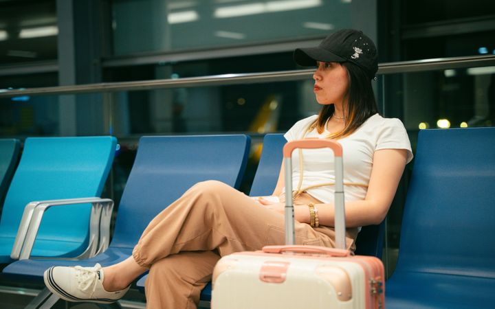 Traveler with a suitcase waiting at an airport gate