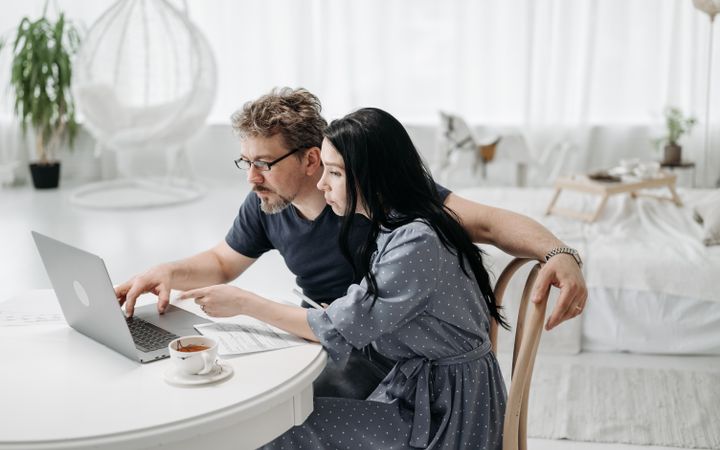 Couple comparing travel plans on a laptop